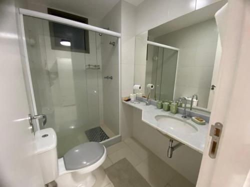 a bathroom with a shower and a toilet and a sink at Loft Reserva do Sahy beira da praia e infra total in Mangaratiba