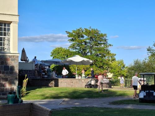 a group of people sitting on a wall with umbrellas at Schloss Krugsdorf Golf & Hotel in Krugsdorf