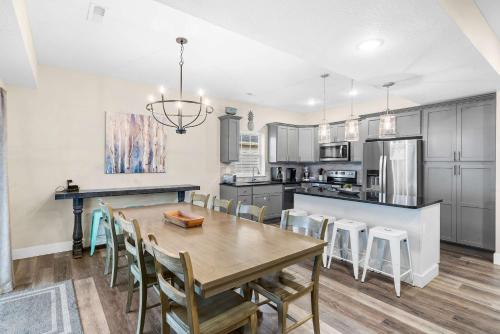 a kitchen and dining room with a wooden table and chairs at Pineapple Bungalow - 14ppl in Hollister