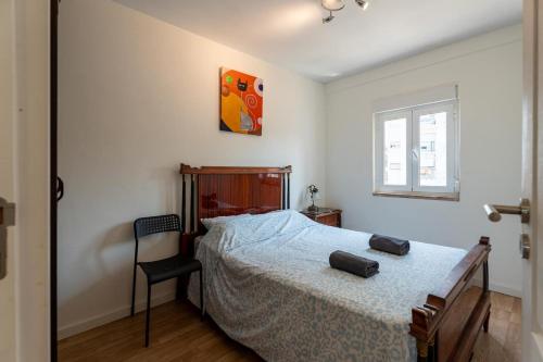 a bedroom with a bed and a chair in it at Olivais 2br - Metro & Airport By Perfect Getaway in Lisbon