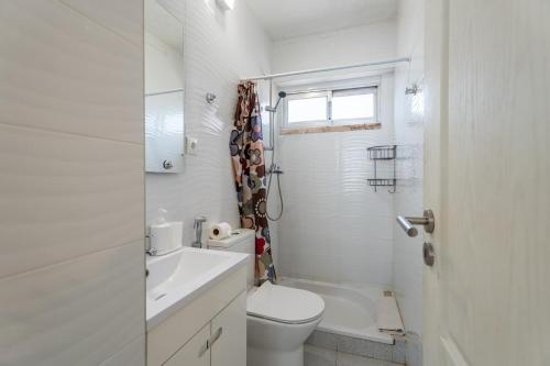 a white bathroom with a toilet and a sink at Olivais 2br - Metro & Airport By Perfect Getaway in Lisbon
