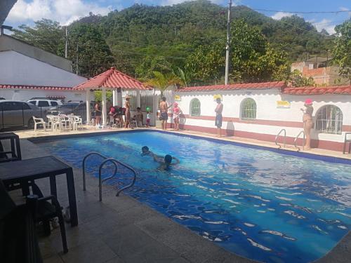 a pool with people playing in the water at Hotel Santo Lomo in La Vega