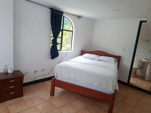 a bedroom with a bed and a window at Hotel Santo Lomo in La Vega
