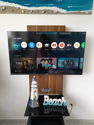 a television screen with a beach show on a table at Apartamento con vista al mar in Pampatar