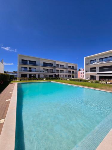 a large swimming pool in front of a building at Mar à sua janela in Oeiras