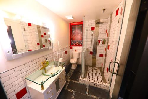Un baño con ducha, lavabo e inodoro. en Printers Alley Downtown Mansion, en Nashville