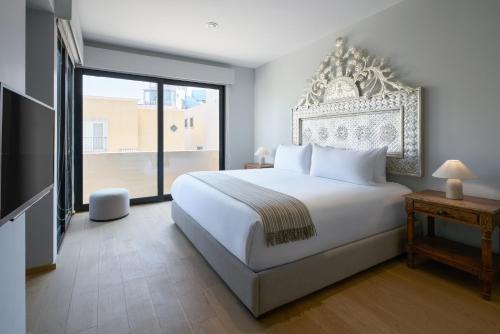 ein Schlafzimmer mit einem weißen Bett und einem großen Fenster in der Unterkunft Mezquite by Viadora in San Miguel de Allende