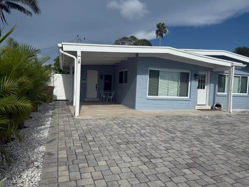 una casa blu con veranda e patio di Indian Rocks Beach Cottage a Clearwater Beach