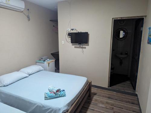 a small room with a bed and a television at Posada hossana in San Andrés