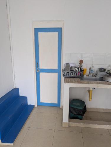 a room with a blue door and a sink at Posada hossana in San Andrés