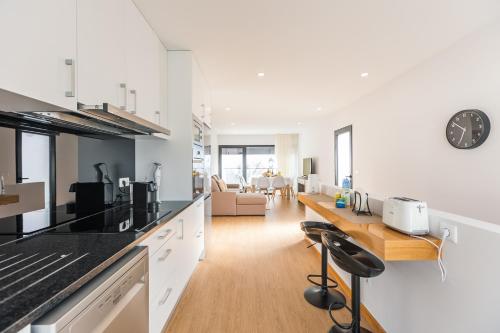 a kitchen with a counter and a living room at Fonte Da Rocha - OCEAN VIEW in Ponta Delgada
