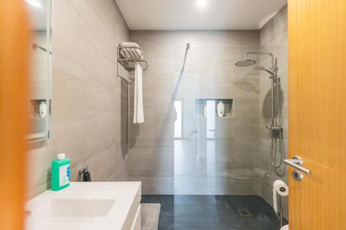 a bathroom with a white sink and a shower at Fonte Da Rocha - OCEAN VIEW in Ponta Delgada