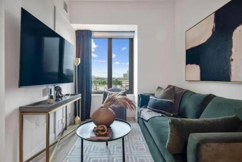 a living room with a green couch and a large window at Luxury Apartments by Hyatus at Boston Cambridge in Boston