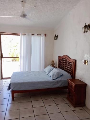 a bedroom with a bed and a window at Casa Luna in Barra de Navidad