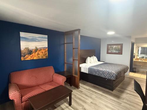 a hotel room with a bed and a chair at Galaxy Inn & Suites in Little Rock