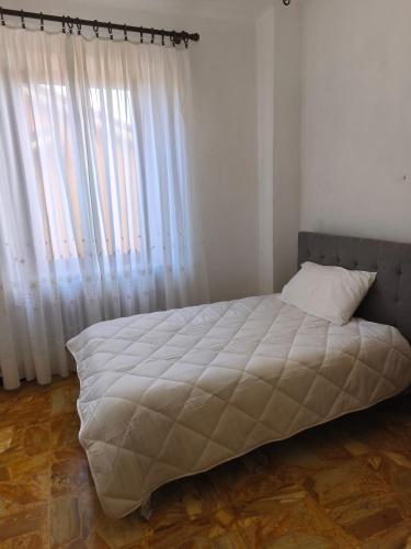 a bed in a bedroom with a large window at Regina Margherita Apartment in Rocchetta Ligure