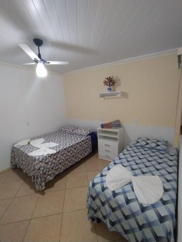 two beds in a bedroom with a ceiling at Kayc pousada in Amargosa