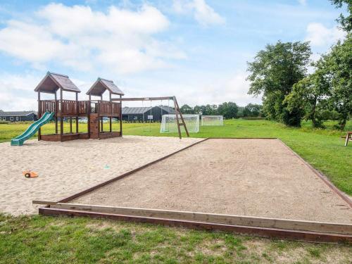 an empty playground with a swing set in a field at 10 person holiday home in Ansager-By Traum in Ansager