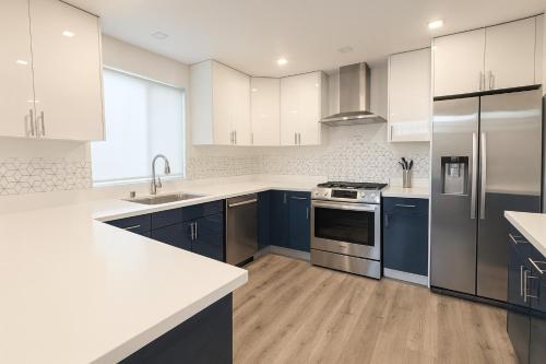 a kitchen with white appliances and blue cabinets at Santa Monica Luxe Home - Hot Tub, Pool Table, Grill & Cinema Projector in Los Angeles