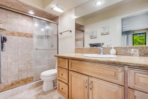 a bathroom with a toilet and a sink and a shower at Lively 2Bd 2Bth condo AC 5 min walk to beach in Lahaina