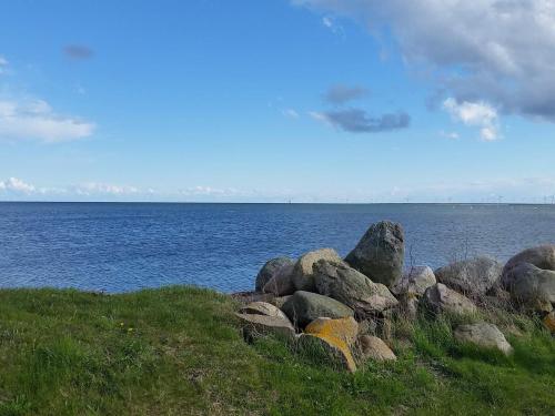 a pile of rocks on the side of a body of water at 5 person holiday home in Holeby in Holeby