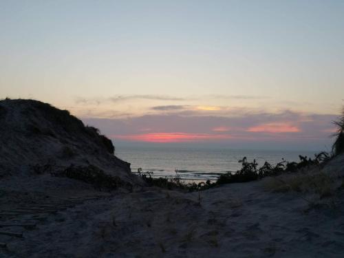 een zonsondergang boven de oceaan op een zandstrand bij 6 person holiday home in Ringkøbing in Ringkøbing
