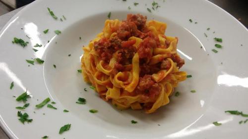 a plate of pasta with meat and sauce at Hotel Main Street in Cerasolo