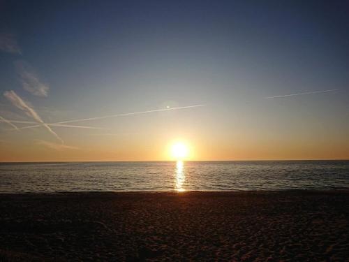 a sunset on the beach with the sun setting at 5 person holiday home in Væggerløse-By Traum in Marielyst