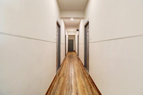 a long hallway with white walls and wood floors at Townhouse Ecity Inn in Bengaluru