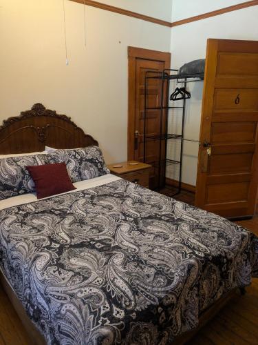 a bedroom with a bed with a blue and white blanket at The Oliver House - Adults Only in Bisbee