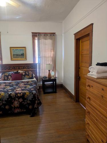 a bedroom with a bed and a dresser and a window at The Oliver House - Adults Only in Bisbee