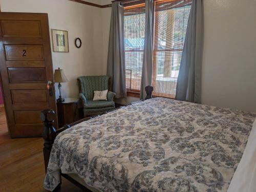a bedroom with a bed and a chair and a window at The Oliver House - Adults Only in Bisbee