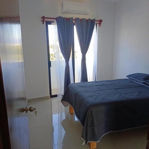 a bedroom with a blue bed and a window at Departamento Casa Bahía in Nuevo Vallarta 