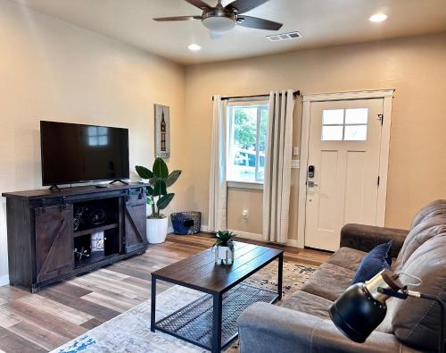 a living room with a couch and a flat screen tv at Charming 2BR Cottage Near Freeway-Cul-de-sac in Medford
