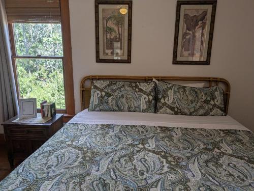 a bedroom with a bed with a bedspread and a window at The Oliver House - Adults Only in Bisbee