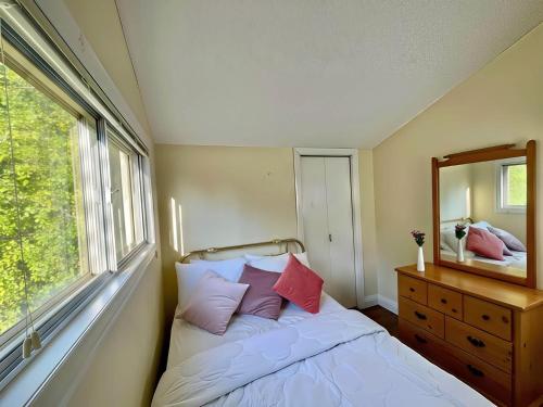 Un dormitorio con una cama con espejo y una cómoda. en 2-Bedroom Cottage #11 - Ambleside, en Kawartha Lakes