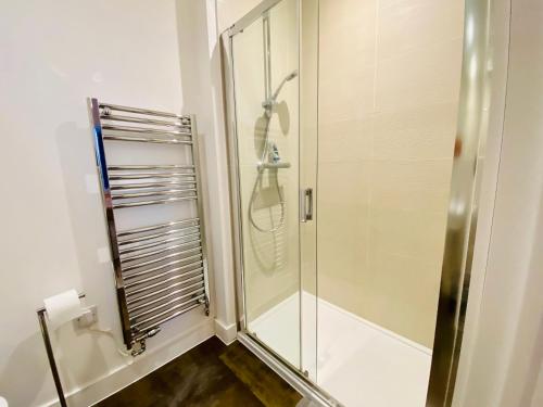 a shower with a glass door in a bathroom at Superb House Sleeps 7 parking in Cambridge in Trumpington