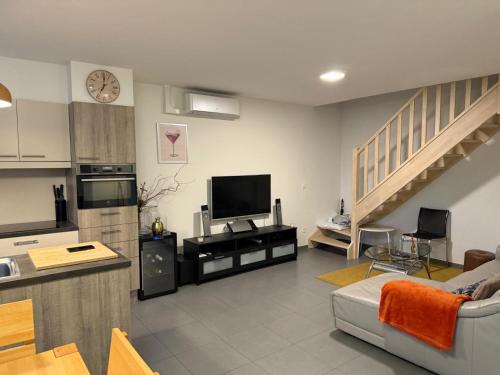 a living room with a couch and a television and stairs at Atomium Victory in Brussels