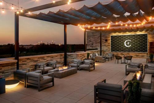 a patio with chairs and tables and lights on it at AC Hotel by Marriott Charlotte SouthPark in Charlotte