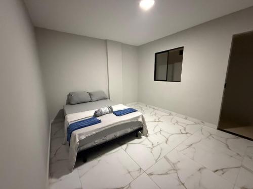 a white room with a bed and a mirror at Apart Hotel São Pedro Inn Caxias in Duque de Caxias