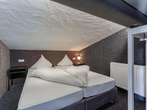 a bedroom with a bed with white sheets and pillows at Chalet H XL in Königsleiten