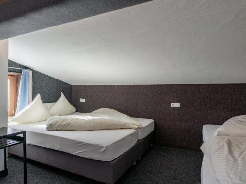 a bedroom with two beds with white pillows at Chalet H XL in Königsleiten
