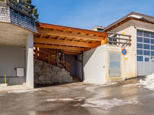 a large white building with a wooden roof at Chalet H XL in Königsleiten