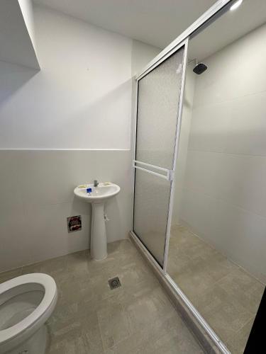 a bathroom with a shower and a toilet and a sink at Jhonny Cay Collection Apartahotel in San Andrés