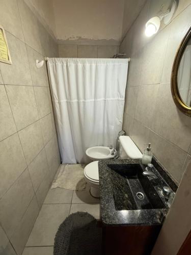 a small bathroom with a sink and a toilet at Sayani Posada in Chilecito