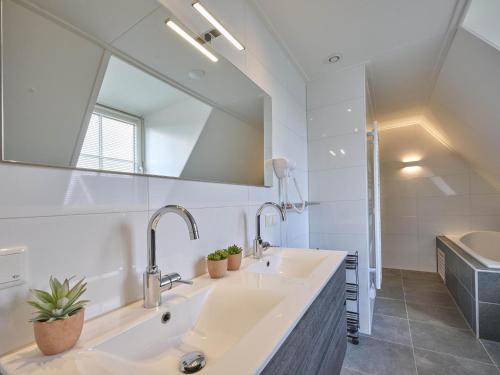 Un baño con dos lavabos y un espejo grande. en Beach deluxe, en Colijnsplaat