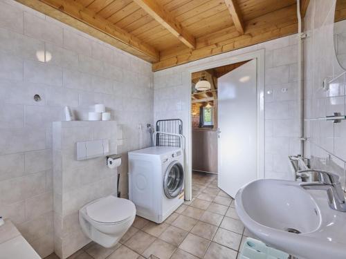 a bathroom with a washing machine and a sink at Erve Koeleman in Diepenheim