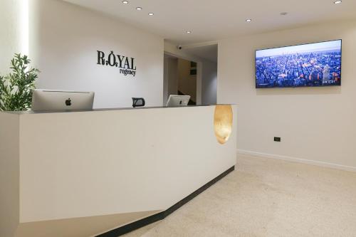 an office with a reception desk and a tv on the wall at Royal Regency Hotel in Cairo
