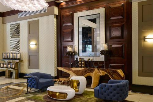 a lobby with a large wooden table and blue chairs at Renaissance Phoenix Downtown Hotel in Phoenix