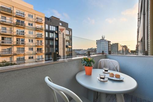 a table and chairs on a balcony with a view of a building at ON Apartments - Matosinhos Premium - Free Parking & Pet Friendly in Matosinhos